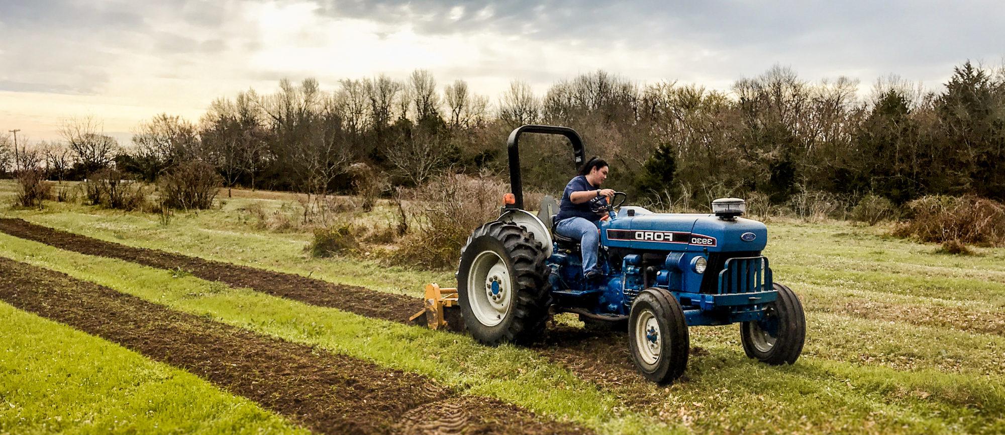 Tamuc student gaining hand-on  experience plowing a field.